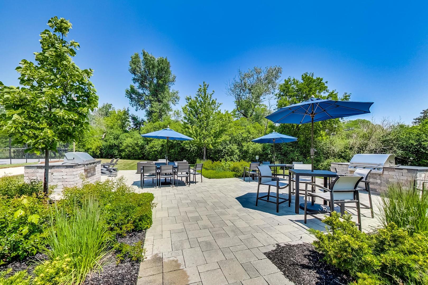 2020 Chestnut Avenue, Unit 312 Glenview, IL 60025 - Photo 26 of 34 a view of a patio with a table and chairs under an umbrella
