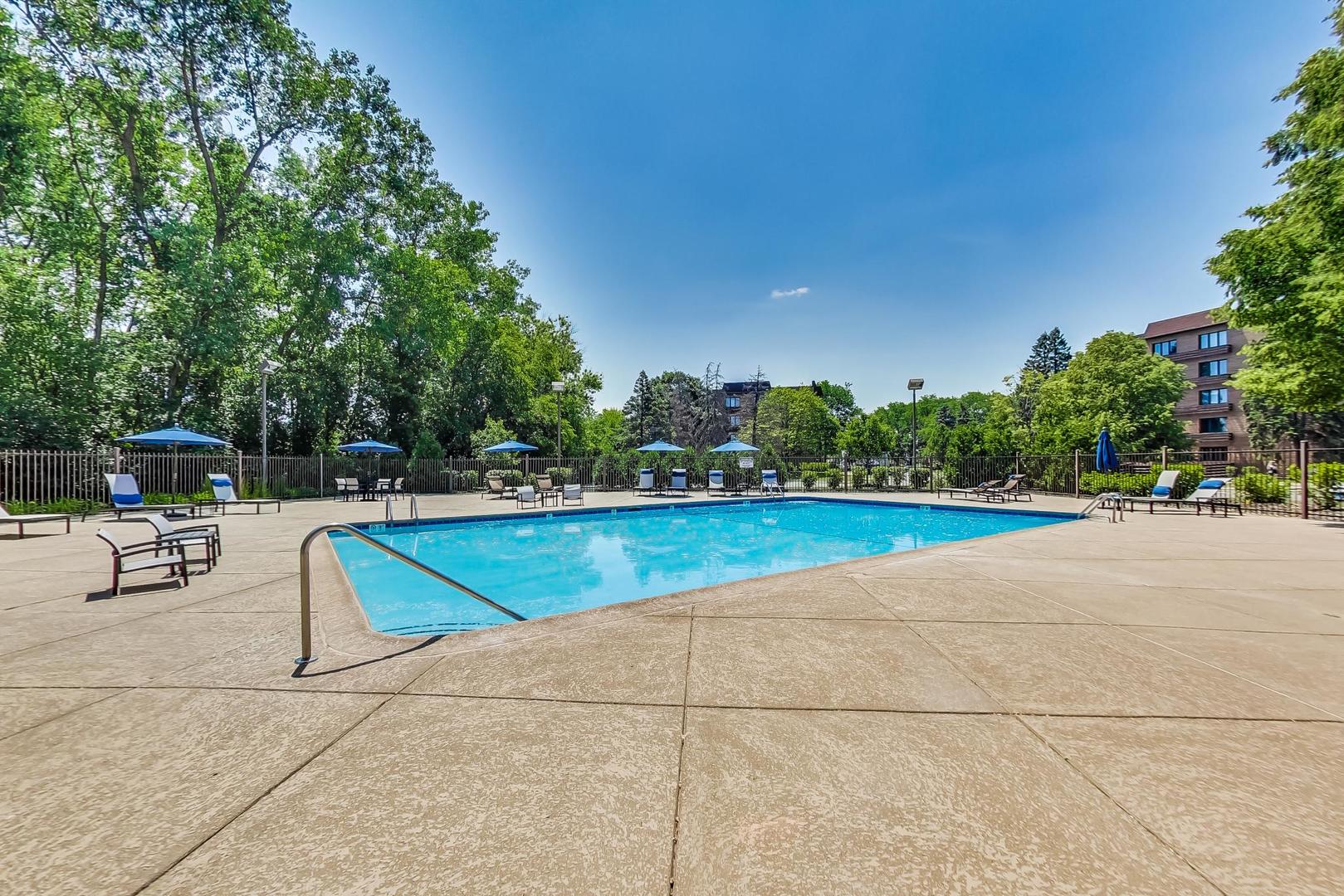2020 Chestnut Avenue, Unit 312 Glenview, IL 60025 - Photo 28 of 34 a view of swimming pool with seating area and trees in the background