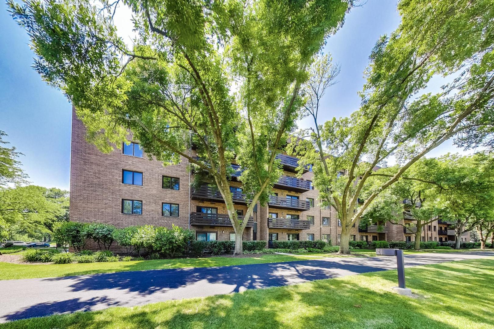 2020 Chestnut Avenue, Unit 312 Glenview, IL 60025 - Photo 31 of 34 a view of a big house with a big yard and large trees