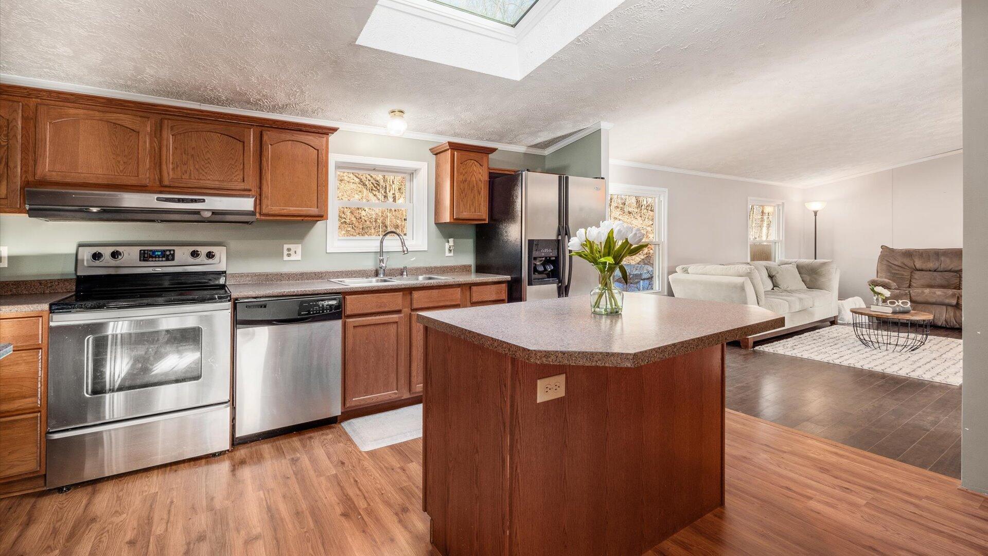 Kitchen with island, skylights and stainless steel appliances