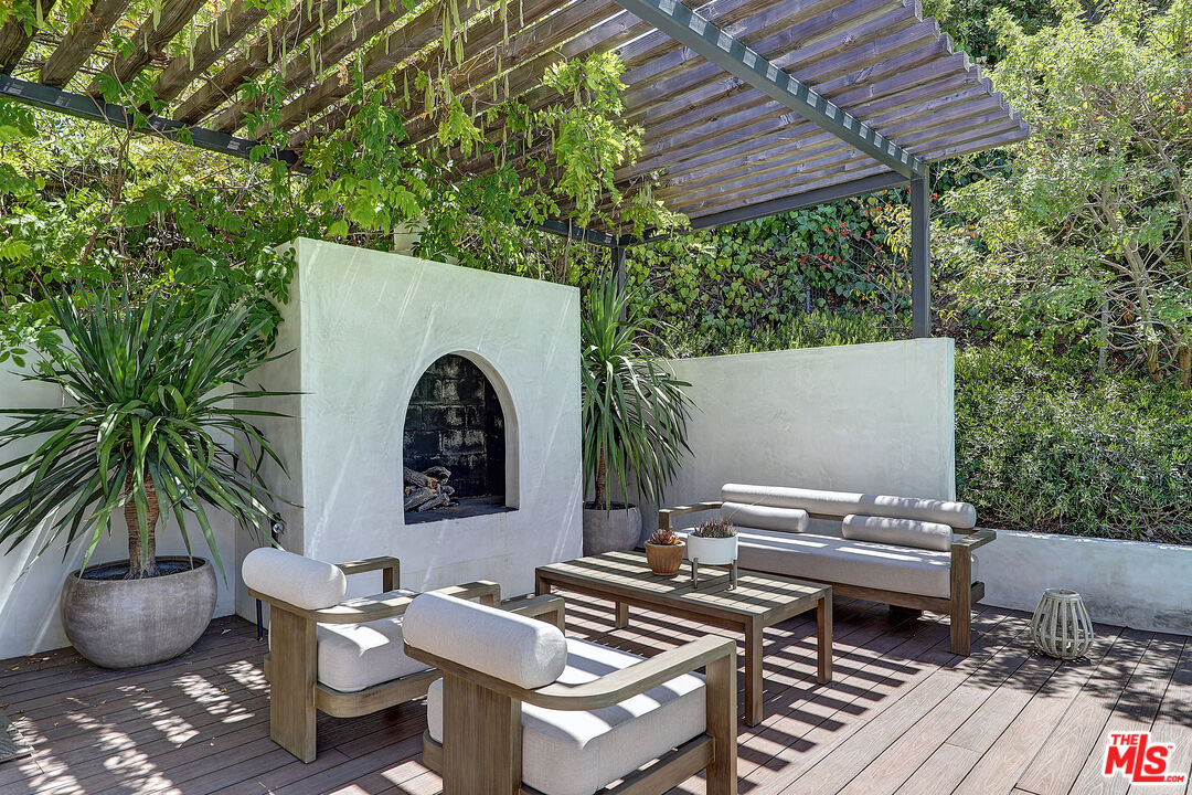 8674 Edwin Drive Los Angeles, CA 90046 - Photo 21 of 53 a view of a patio with table and chairs potted plants and a palm tree