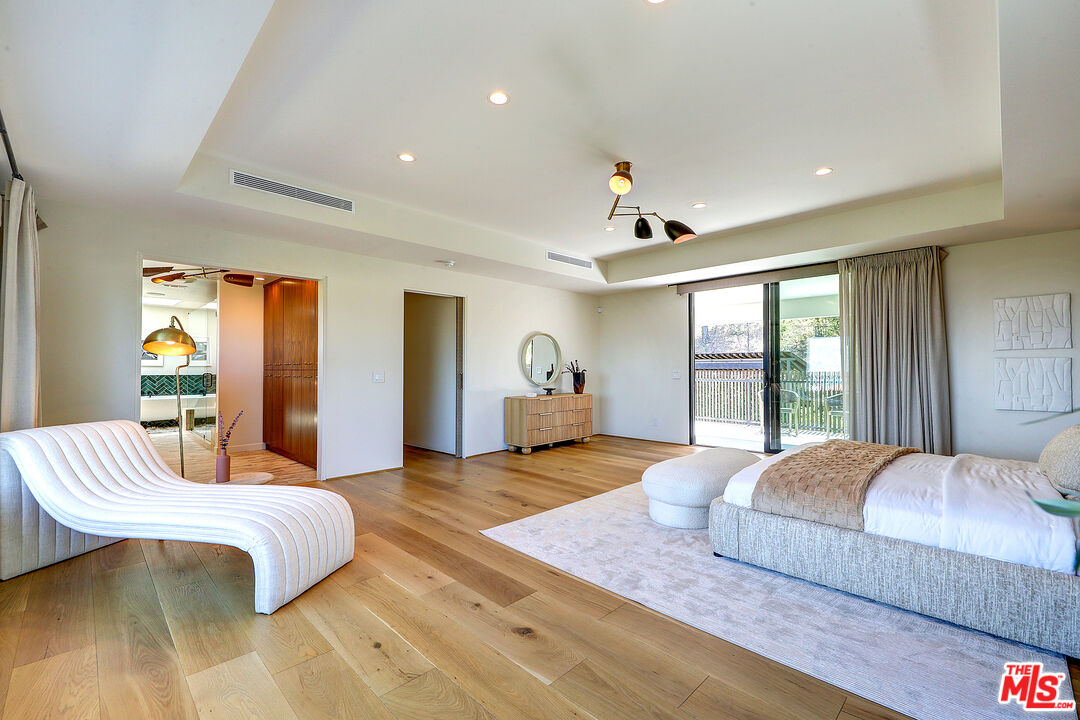 8674 Edwin Drive Los Angeles, CA 90046 - Photo 28 of 53 a bedroom with a large bed and wooden floor
