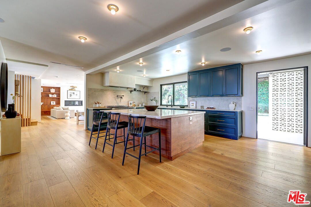 8674 Edwin Drive Los Angeles, CA 90046 - Photo 8 of 53 a kitchen with stainless steel appliances granite countertop a stove top oven a sink dishwasher a dining table and chairs with wooden floor