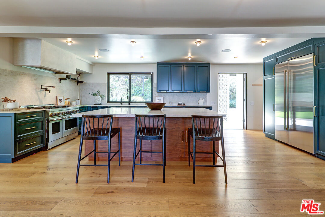 8674 Edwin Drive Los Angeles, CA 90046 - Photo 9 of 53 a kitchen with stainless steel appliances granite countertop wooden floor a dining table and chairs
