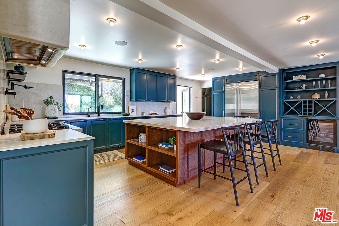 8674 Edwin Drive Los Angeles, CA 90046 - Photo 10 of 53 a living room with stainless steel appliances kitchen island granite countertop a table chairs and a refrigerator