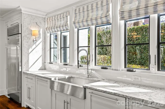 a living room with furniture fireplace and a large window