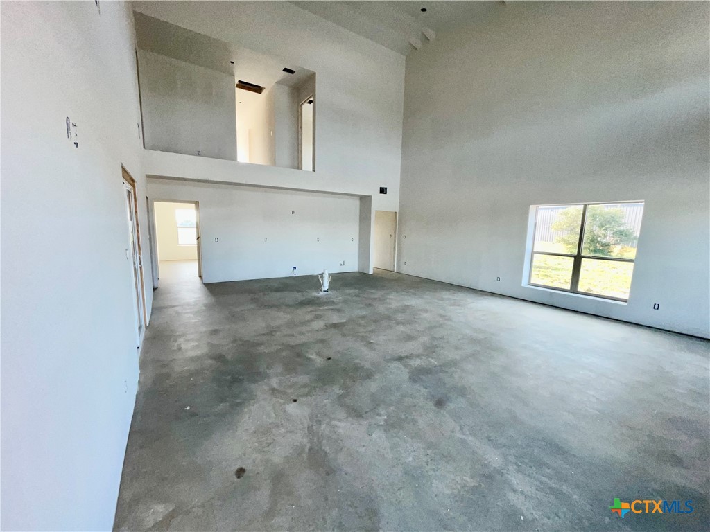 29 Carrie Street Port O'Connor, TX 77982 - Photo 5 of 29 an empty room with a fireplace and windows