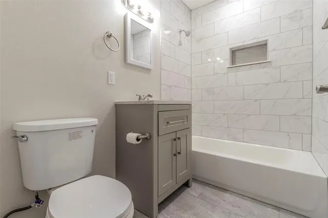 a bathroom with a granite countertop toilet a sink and bathtub