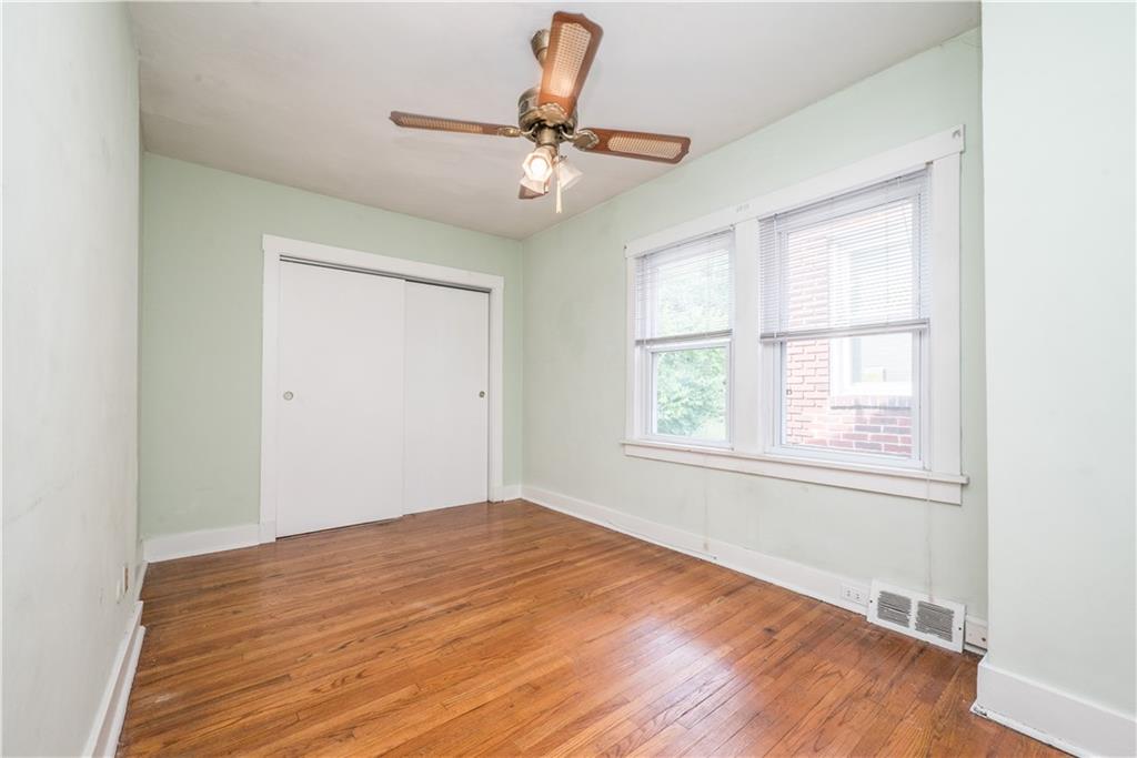1819 Viruth Street Pittsburgh, PA 15212 - Photo 29 of 50 an empty room with wooden floor chandelier fan and windows
