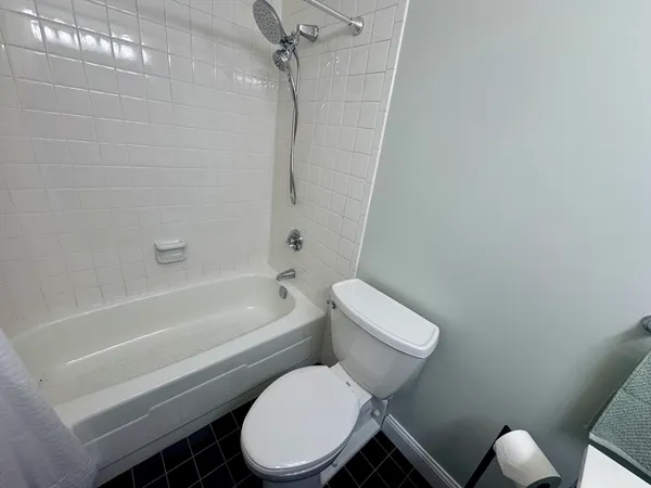 a white toilet and tub sitting next to a bathroom sink