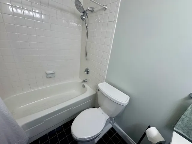 a white toilet and tub sitting next to a bathroom sink