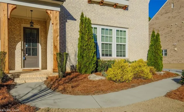 an empty room with wooden floor fireplace and windows