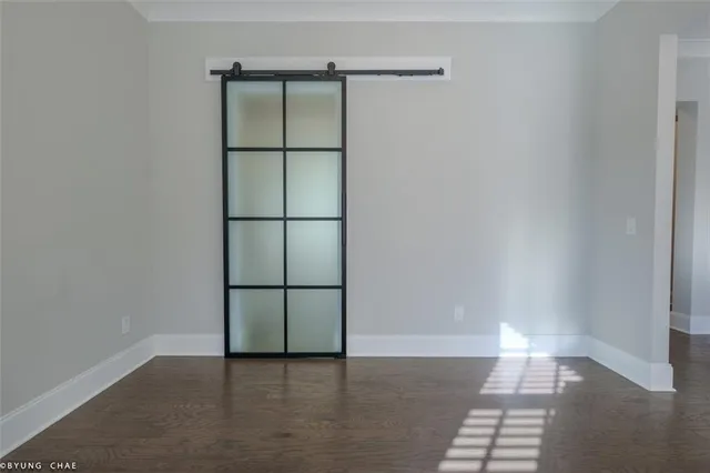 a view of an empty room with a kitchen and wooden floor