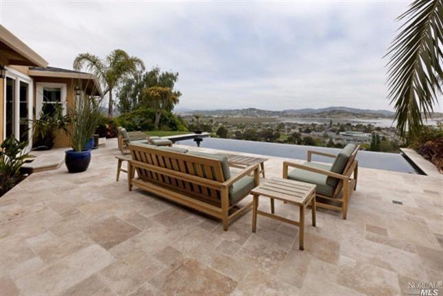 a view of a roof deck with couches and wooden fence
