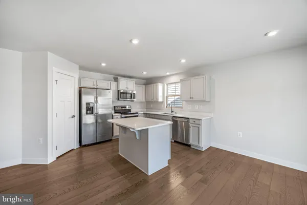 a kitchen with a refrigerator and a stove top oven