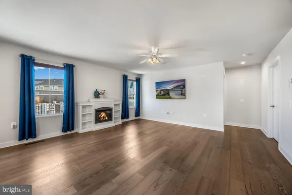 a view of empty room with wooden floor and fireplace