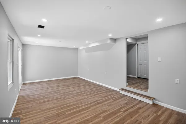 a view of an empty room with wooden floor