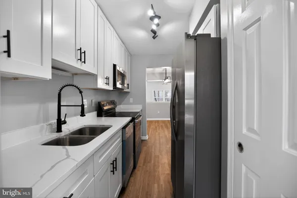 a kitchen with stainless steel appliances sink a refrigerator and cabinets
