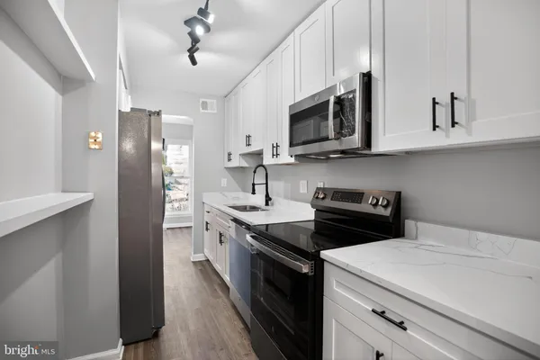 a kitchen with stainless steel appliances granite countertop white cabinets sink and stainless steel appliances