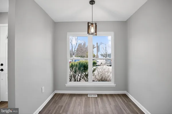 a view of a hallway with wooden floor and a window