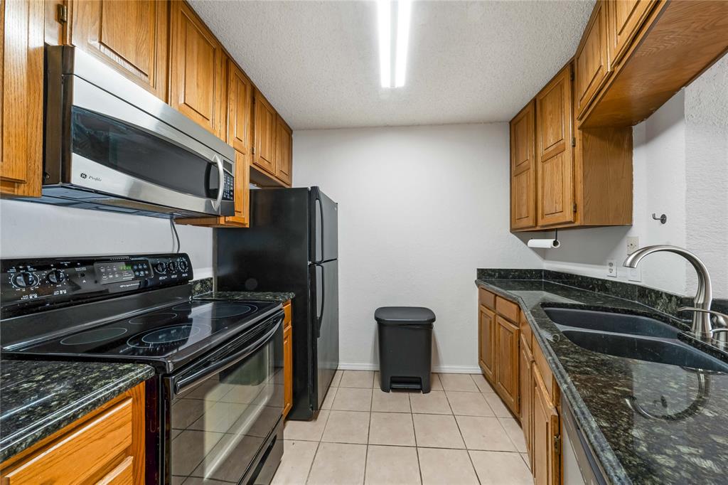 13217 Emily Road, Unit 3209 Dallas, TX 75240 - Photo 4 of 26 a kitchen with stainless steel appliances granite countertop a stove a sink and a microwave