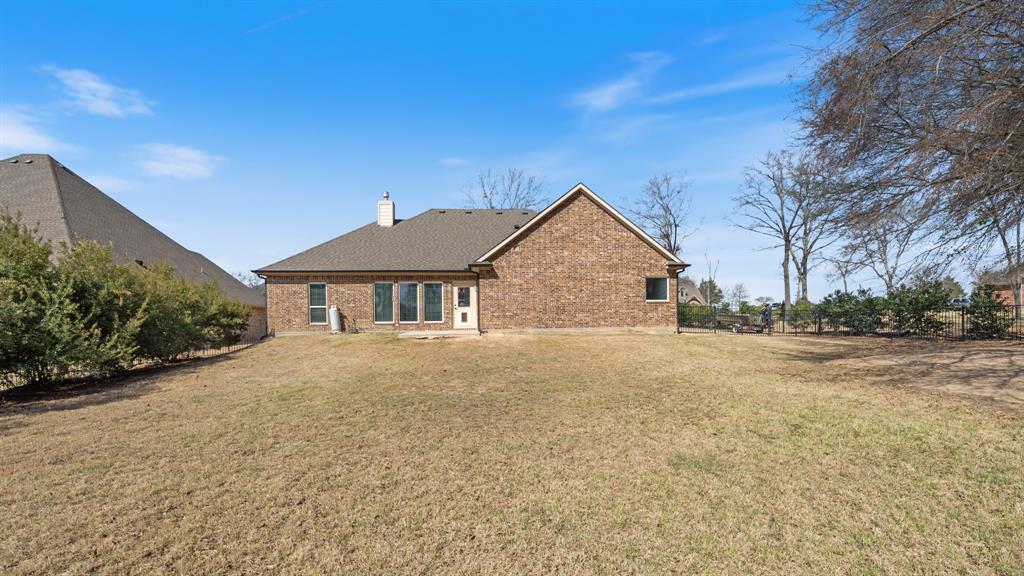 101 Lighthouse Lane Mabank, TX 75143 - Photo 27 of 40 Back of property with a yard, brick siding, and a chimney