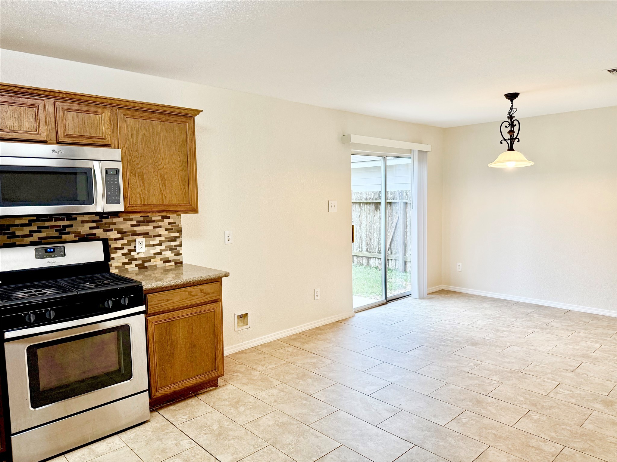 3814 Silver Bridge Lane Katy, TX 77449 - Photo 5 of 20 a kitchen with granite countertop a stove and a microwave