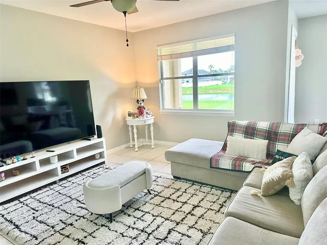 a living room with furniture a flat screen tv and a window