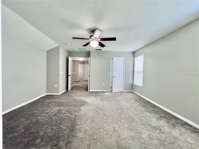 a view of an empty room with a ceiling fan