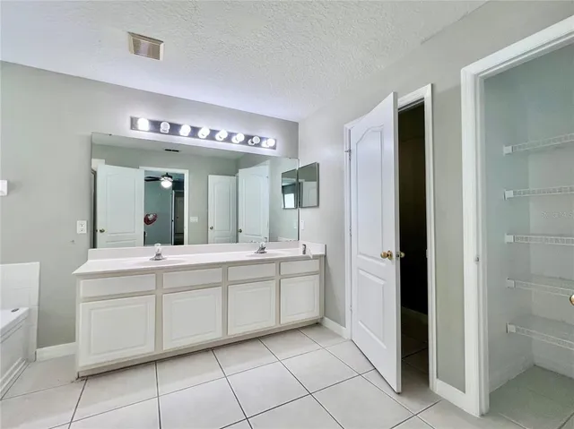 a spacious bathroom with a double vanity sink and a mirror