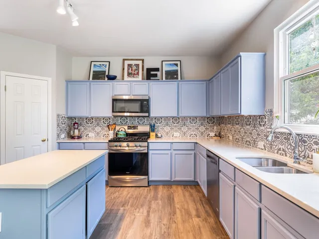 a kitchen with stainless steel appliances granite countertop a sink and stove top oven