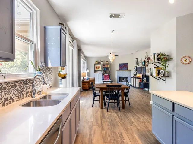a kitchen with stainless steel appliances a dining table chairs and wooden floor