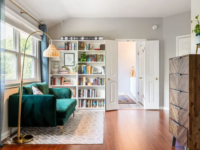 a living room with furniture and a book shelf