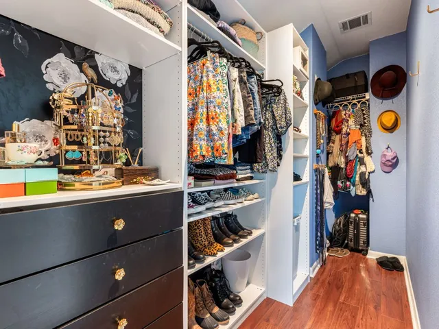 a view of walk in closet with clothes and shoes