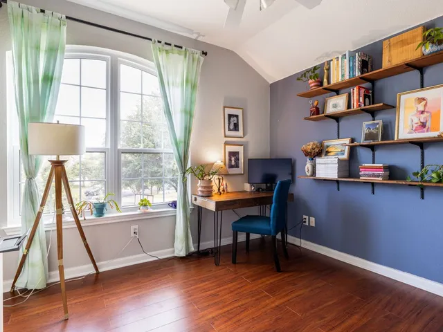 a view of a workspace with furniture and a window