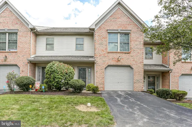 a front view of a house with a garden and plants