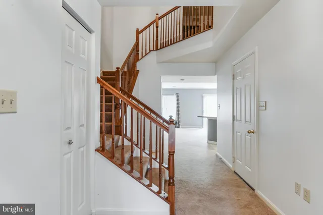 a view of staircase with lots of frames on wall and wooden floor