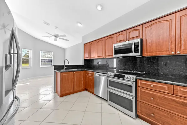 a kitchen with stainless steel appliances granite countertop a sink stove and refrigerator