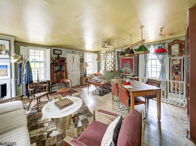 a living room with furniture kitchen view and a wooden floor