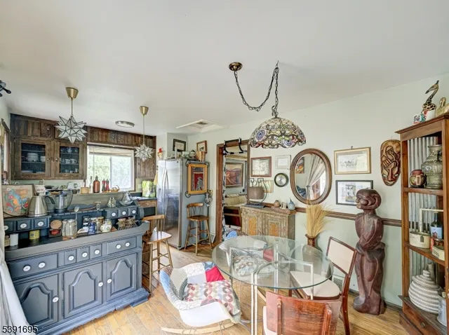 a kitchen with stainless steel appliances kitchen island granite countertop a stove a sink a dining table and chairs with wooden floor