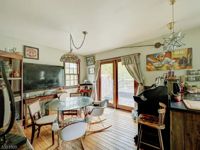 a living room with furniture a flat screen tv and floor to ceiling window