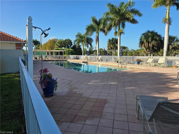 a view of house with swimming pool lawn chairs and palm tree