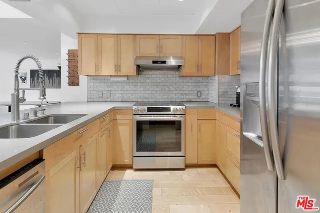 a kitchen with granite countertop a sink cabinets and stainless steel appliances