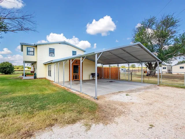 a view of a house with backyard and sitting area