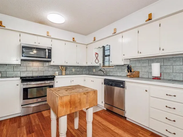 a kitchen with granite countertop wooden cabinets and stainless steel appliances
