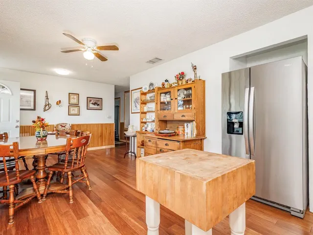 a dining hall with stainless steel appliances granite countertop a dining table and chairs with wooden floor