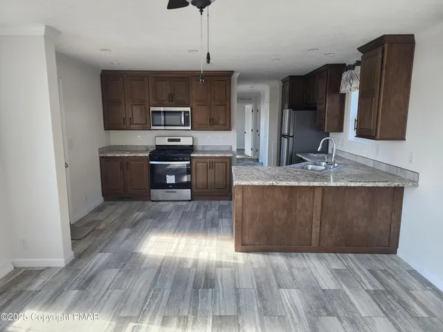 a kitchen with a sink wooden floor and stainless steel appliances