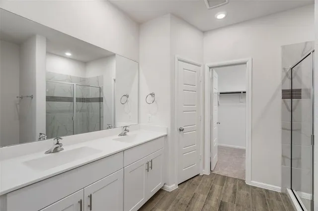 a bathroom with a double vanity sink a mirror and a shower