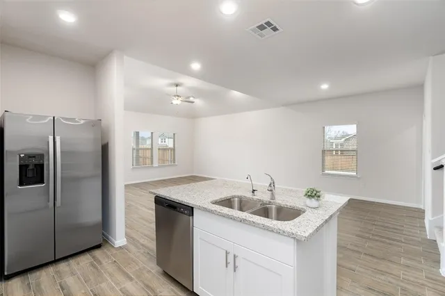 a kitchen that has a sink cabinets counter space and stainless steel appliances