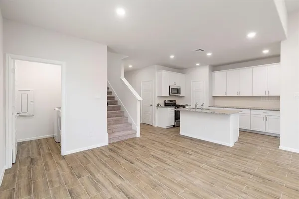 a view of kitchen with wooden floor and electronic appliances